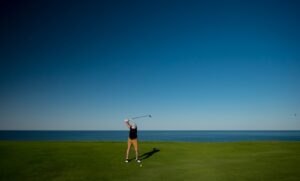 man standing on green grass field playing golf